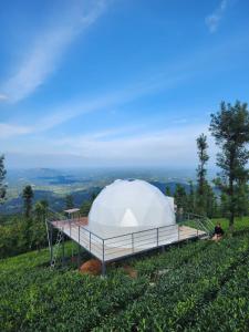 une grande tente blanche au sommet d'une colline dans l'établissement Vythiri Tea valley, à Vythiri