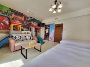 Un dormitorio con una cama, un sofá y una mesa. en 海洋柔情-旅遊補助-日租 包棟-親子 寵物友善 溜滑梯 海洋公園 沙灘車 天空之鏡, en Jian