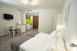 a bedroom with a bed and a kitchen with a table at Arima city in Shumen