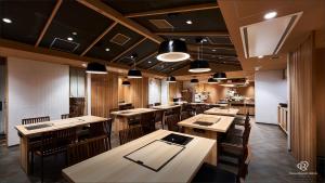 東京的住宿－Daiwa Roynet Hotel Shimbashi，用餐室配有木桌和椅子