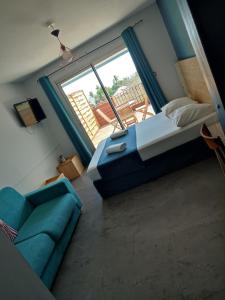 sypialnia z łóżkiem, kanapą i oknem w obiekcie MARINA , 2mn à PIEDS PLAGE BOUCAN CANOT w mieście Saint-Gilles les Bains