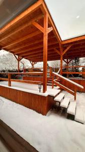 a pavilion with benches and snow on the ground at Góralska Chata & Spa in Muszyna