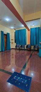 una habitación con sillas y una pista de baile con cortinas azules en Ghar Of Arambol, en Old Goa