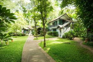a house with a walkway in front of a yard at E-Outfitting Doikham Resort in Chiang Mai