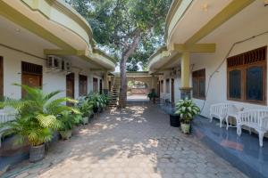 a courtyard of a house with white chairs and plants at RedDoorz Syariah at Jalan Sunan Giri Tuban in Tuban