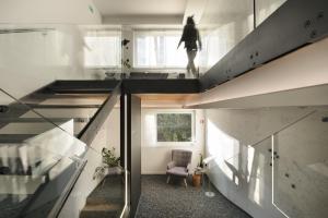 a staircase in a house with a person standing in the window at CITYMAP HOTEL APARTMENTS Maribor-Free parking! in Maribor