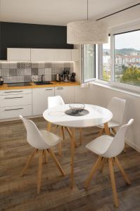 a kitchen with a white table and white chairs at CITYMAP HOTEL APPARTMENTS Maribor-Free parking! in Maribor