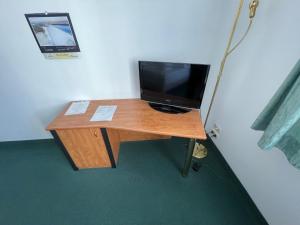 a wooden desk with a television on top of it at Hotel & Restaurant Bergfried in Saalfeld
