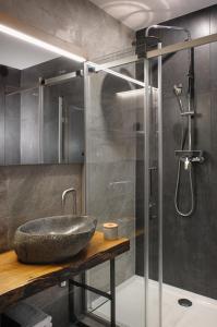 y baño con lavabo de piedra y ducha. en Apartments CityMap Maribor-Free parking!, en Maribor