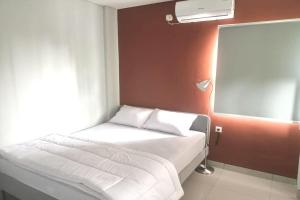 a small bedroom with a bed and a window at OYO 93514 Rubina Syariah Hotel in Purbolinggo