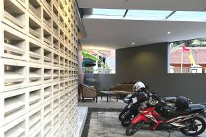 a motorcycle parked next to a wall with empty shelves at OYO 93514 Rubina Syariah Hotel in Purbolinggo