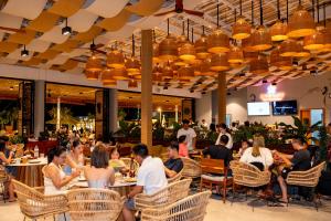 un grupo de personas sentadas en mesas en un restaurante en Summer Bay Beach Club & Cabins en Sihanoukville