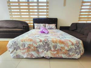 une petite fille assise sur un lit dans une pièce dans l'établissement Gem Suites Minimalist 2BR 4beds Entire Apartment, à Kuching