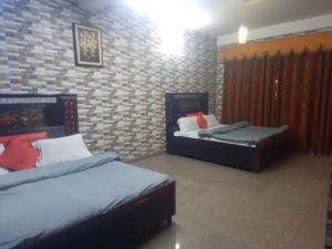 a bedroom with two beds and a brick wall at Sita Chalet Manali in Manāli