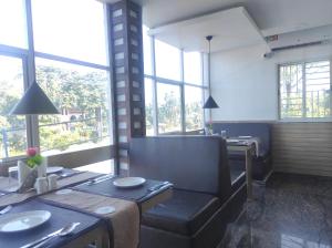 a dining room with a table and chairs and windows at Hotel Prova in Koch Bihār