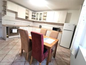 - une cuisine avec une table et des chaises en bois dans l'établissement Elements Apartments, à Ostrov