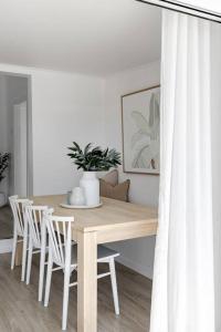塞斯諾克的住宿－Casa Wilde in the Hunter，餐桌、白色椅子和木桌