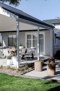 a patio with a table and chairs and a roof at Casa Wilde in the Hunter in Cessnock +20 photos