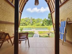 a screened in porch with a view of a garden at Uma Raos Cottage in Ubud