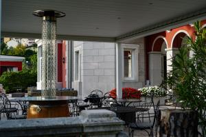 un patio con tavoli, sedie e fontana di Villa Bottacin a Trieste