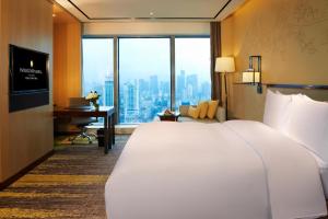 福州市にあるInterContinental Fuzhouの大きなベッドとデスクが備わるホテルルームです。