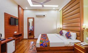 - une chambre avec un lit, un bureau et une télévision dans l'établissement FabHotel Prime Noida Sector 63, à Noida