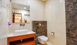 a bathroom with a sink and a toilet and a mirror at FabHotel Prime Noida Sector 63 in Noida