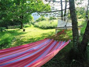 Una hamaca está atada a un árbol en un patio. en Countryhouse Lake Attersee - Traumhaft schöne Lage - Bezauberndes Hideaway, en Unterach am Attersee