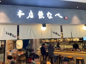 OrioゲストハウスＥn プレザント203的一群人坐在餐厅柜台上