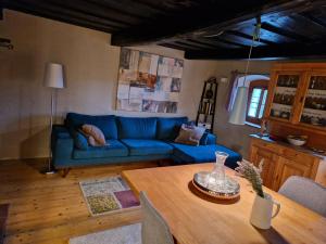 a living room with a blue couch and a table at Uriges Bauernhaus in den Bergen 