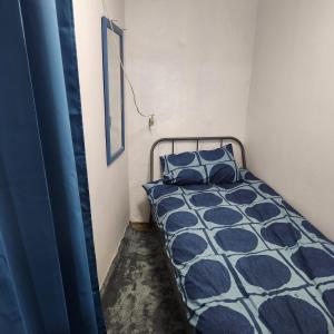 un letto con cuscini blu in una piccola stanza di Hanil Hostel a Seul