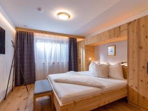 エルマウにあるAppartementhaus Bambiの木製の壁のベッドルーム1室(大型ベッド1台付)
