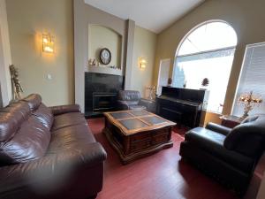 a living room with a leather couch and a coffee table at Comfortable Utopia B&B in Richmond