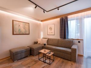 ein Wohnzimmer mit einem Sofa und einem Tisch in der Unterkunft Appartementhaus Bambi in Ellmau