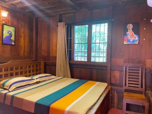 a bedroom with a bed in a room with wooden walls at Mayoorapanjaram in Neyyāttinkara