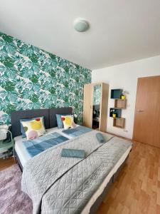 #Klauzál11#Design Apartment #2BDRM في بودابست: غرفة نوم بسرير كبير وورق جدران اخضر وابيض