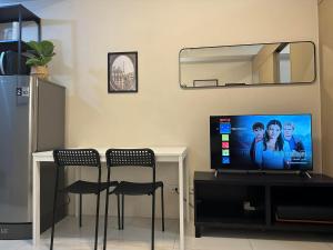 ein Wohnzimmer mit einem Tisch mit 2 Stühlen und einem TV in der Unterkunft Elane's Staycation -Mezza 2 1 br in Manila
