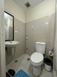 y baño con aseo blanco y lavamanos. en Elane's Staycation -Mezza 2 1 br, en Manila