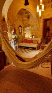 een slaapkamer met een hangmat in een stenen kamer bij Ta' Didi B&B in Kerċem