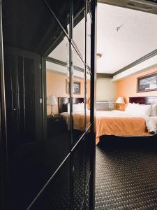 a hotel room with a bed with orange sheets at Quality Inn & Suites in Hinton