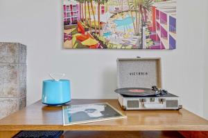 a table with a record player and a radio on it at Idyll in the Desert - Immaculate Palm Desert Getaway in Palm Desert +27 photos