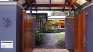 uma entrada para uma casa com um portão de madeira em A Tropical Treat - Sea Level Port Douglas em Port Douglas