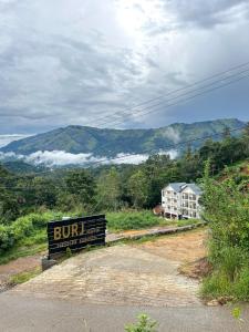 a sign on the side of a road with a building at MUNNAR MISTY BLOW in Munnar