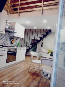 uma cozinha com uma mesa e cadeiras e uma escadaria em Suite per famiglie"Civico 65" em Palagianello