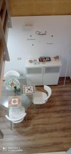 ein Esszimmer mit einem Tisch und weißen Stühlen in der Unterkunft Suite per famiglie"Civico 65" in Palagianello