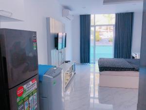 um quarto com uma cama e uma televisão em Căn hộ Ocean Vista 1br Garden View - SeaHome em Phan Thiet