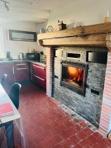 a fireplace in a kitchen with a fire place at Maison en Colombage in Tilly