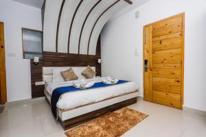 1 dormitorio con 1 cama y puerta de madera en DESTINATION By EXOTICA, en Dharamshala