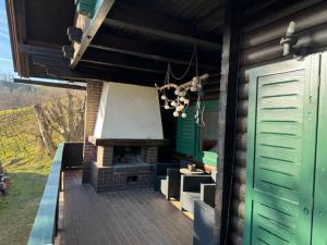 a outdoor patio with a fireplace and green doors at Ferienhaus Maximilian in Gamlitz