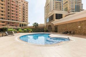une grande piscine au milieu d'un bâtiment dans l'établissement Beautiful 1BR Apt with city views at silicon Dubai, à Dubaï